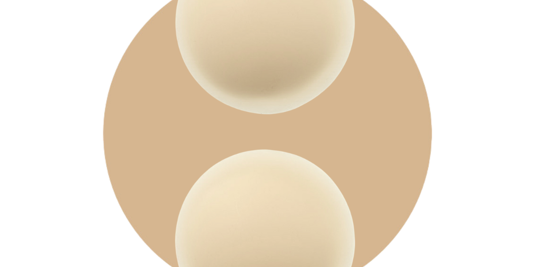 Silicone reusable nipple covers for light and tanned skin tones on a beige background.
