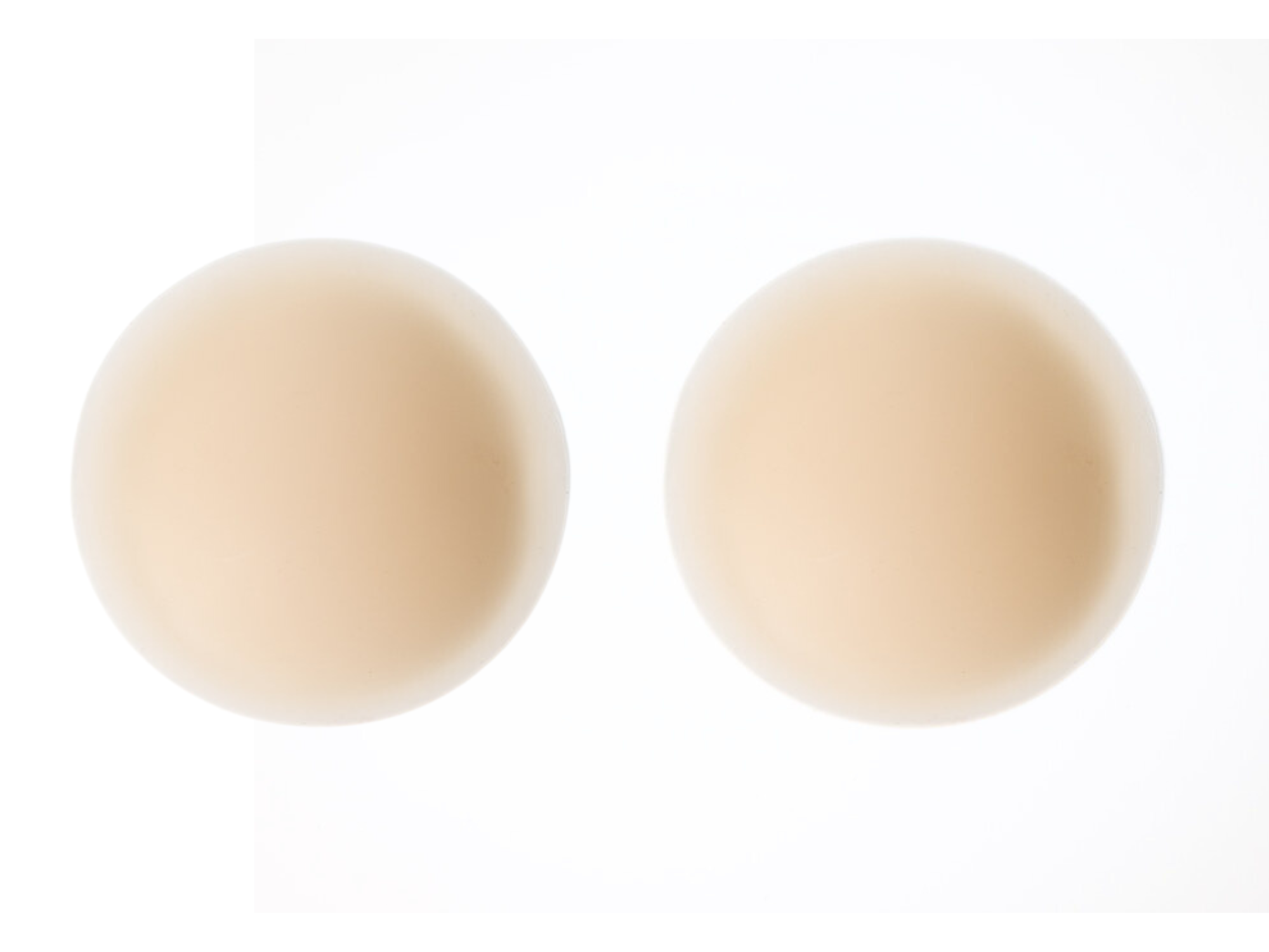 A pair of light beige silicone nipple pasties on a white background.