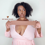 A sexy Black woman wearing nude color boob tape in the color "brown sugar". 