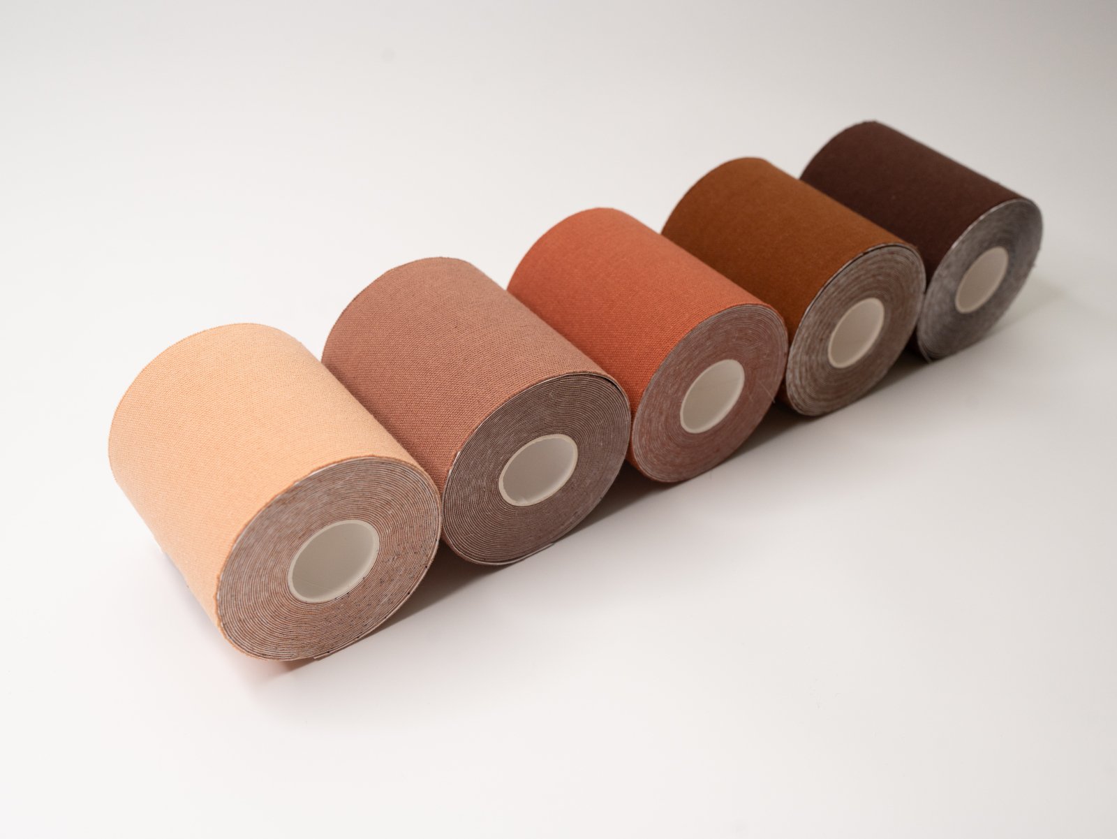 Rolls of nude-colored boob tape lined up for women of all colors and shades.